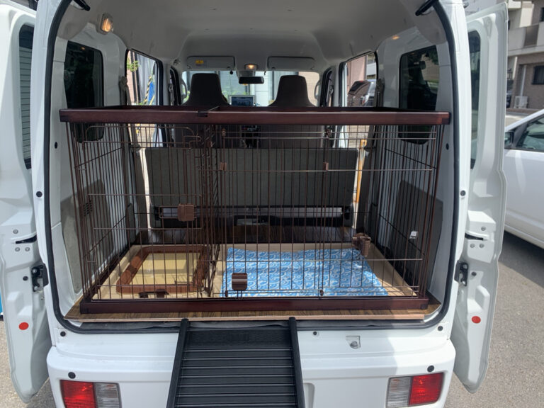 軽バンの荷室に設置したペット用ケージ。ケージの床にマットを敷き、後部ドアを開けた状態